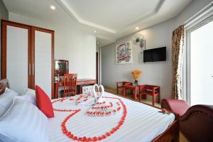 una camera da letto con un letto con un nastro rosso sopra di Quang Hoa Airport Hotel ad Ho Chi Minh