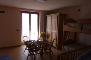 a dining room with a table and chairs and a bunk bed at Agriturismo Ca' di Racc in Gromo