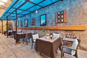un restaurante con mesas, sillas y una pared en StayVista at Stonehill Manor with Outdoor Sitting, en Dharamshala