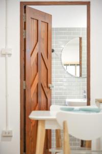 a bathroom with a wooden door and a mirror at SLEEP SLEEP SUANPHAK in Ban Khlong Bang Sai