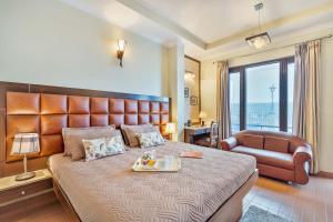 1 dormitorio con 1 cama grande y 1 silla en StayVista at Stonehill Manor with Outdoor Sitting, en Dharamshala