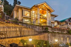 una casa con escaleras que conducen a ella en StayVista at Stonehill Manor with Outdoor Sitting, en Dharamshala