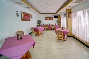 a dining room with pink tables and chairs at SUPER OYO 91805 Hotel Wisma Bari in Palembang