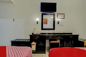 a dressing room with a mirror and a piano at SUPER OYO 91805 Hotel Wisma Bari in Palembang