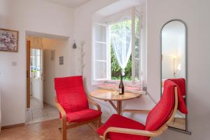 una stanza con sedie rosse, tavolo e finestra di Apartman studio Stari Grad - 1 a Stari Grad (Cittavecchia)