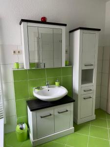 a bathroom with a sink and a mirror at Ferienwohnung Apfeltraum in Thale