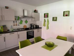 a kitchen with a white table and green chairs at Ferienwohnung Apfeltraum in Thale