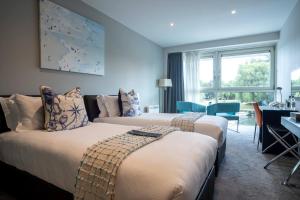 2 letti in una camera d'albergo con finestra di Captain's Club Hotel & Spa a Christchurch