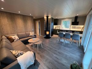 Olderfjord Lodge في Russenes: غرفة معيشة مع أريكة وطاولة ومطبخ