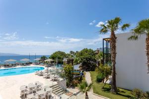 an aerial view of a resort with a pool and palm trees at CHARM BEACH HOTEL in Akyarlar