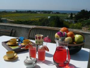 a table with a bowl of fruit and glasses on it at Casale Due Palme in Favignana