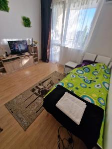 1 dormitorio con 1 cama con edredón verde en Апартамент широк център варна15 минути до центъра, en Varna