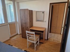 1 dormitorio con escritorio, silla y mesa en Апартамент широк център варна15 минути до центъра, en Varna