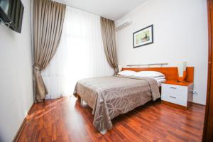 a bedroom with a bed and a wooden floor at Ardager Residence in Atyrau