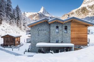 un lodge de ski dans la neige avec des montagnes en arrière-plan dans l'établissement Apartment in Chalet Pizzo Fiamma, à Zermatt