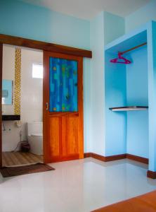 a bathroom with a wooden door and a toilet at i-Style Lanta Boutique House --- SHA Extra Plus in Ko Lanta