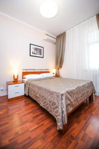 - une chambre avec un grand lit et du parquet dans l'établissement Ardager Residence, à Atyraū