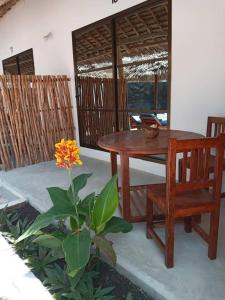 um quarto com uma mesa, uma cadeira e uma planta em Amani Hotel Paje em Paje