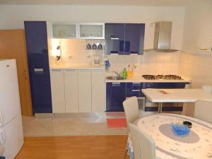 a kitchen with blue and white cabinets and a table at Apartment in Valbandon - Istrien 27864 in Valbandon