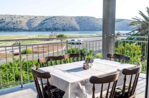 a table on a balcony with a view of the ocean at Apartments in Lopar - Insel Rab 26467 in Lopar