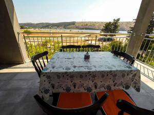 a table on a balcony with a view of the beach at Apartments in Lopar - Insel Rab 26467 in Lopar