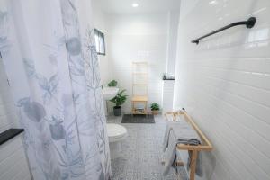 a bathroom with a toilet and a shower curtain at SLEEP SLEEP SUANPHAK in Ban Khlong Bang Sai