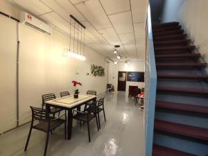 a dining room with a table and chairs and a staircase at JAVA 6 HOME 5 min to Jonker in Melaka