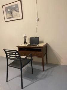 a desk with a laptop computer and a chair at JAVA 6 HOME 5 min to Jonker in Melaka
