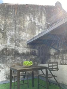 a table with two chairs and a bowl of greens on it at JAVA 6 HOME 5 min to Jonker in Melaka