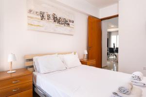 a bedroom with a large bed with white sheets and towels at The Saline Views Makenzy in Larnaca +16 photos