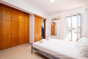 sypialnia z dużym łóżkiem i drewnianymi szafkami w obiekcie The Saline Views Makenzy w Larnace