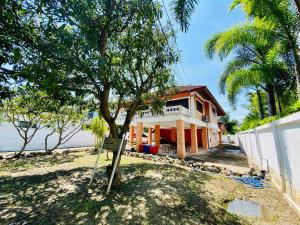 a house with a tree in front of it at Ma Baan House by the sea in Cha Am Beach