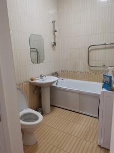 a bathroom with a toilet and a sink and a tub at Сканди-однушка на Пирамиде in Promyshlennyy