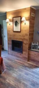 sala de estar con chimenea y pared de madera en L'Etape gourmande, chambres d'hôtes, en Wellin