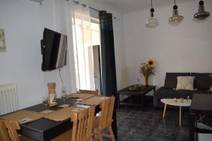 a living room with a table and a tv and a couch at h2h Levandre Άνετο διαμέρισμα στην Καλλιθέα in Athens