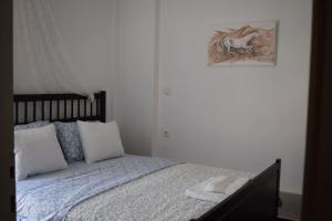 a bedroom with a bed with a picture on the wall at h2h Levandre Άνετο διαμέρισμα στην Καλλιθέα in Athens