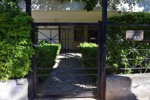an open gate to a house with green plants at h2h Levandre Άνετο διαμέρισμα στην Καλλιθέα in Athens