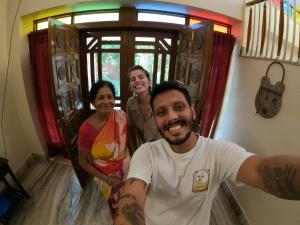 mężczyzna i trzy kobiety stojące przed drzwiami w obiekcie Home of the world w mieście Dżajpur