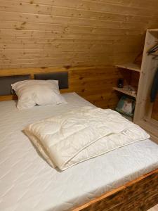a large white bed in a wooden cabin at Gabel&Jurgen in Mirsk