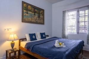 a bedroom with a blue bed with a tray of food on it at Misty Mountains Cottage - In the Lap of Nature! in Kasauli