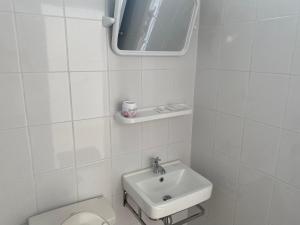 Ban Mungにあるกนกกานต์โฮมสเตย์の白いバスルーム(トイレ、シンク付)