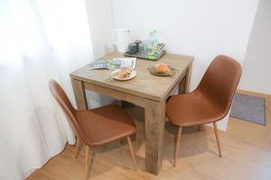 a wooden table with two chairs and a plate of food on it at SLEEP SLEEP SUANPHAK Homestay in Ban Khlong Bang Sai