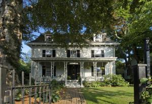 an old white house with a fence in front of it at Marshall Slocum Inn in Newport