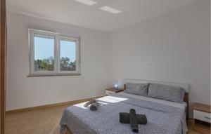a white room with a bed and a window at Stunning Apartment In Njivice With Wifi in Njivice
