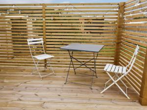 a table and two chairs on a wooden deck at Shepherds Beachhouse in Pagham