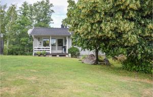 a small white house with a tree in the yard at Awesome Home In Oskarshamn With 1 Bedrooms And Wifi in Oskarshamn