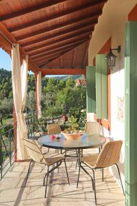 eine Terrasse mit einem Tisch und Stühlen auf dem Balkon in der Unterkunft Blue & Green Villa in Panormos Skopelos