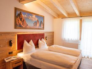 ein Schlafzimmer mit 2 Betten und einem Bild an der Wand in der Unterkunft Rodahof in Sexten