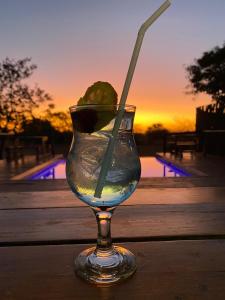 a glass of water with a lime and a straw at Roaring Sky Base Camp in Cullinan