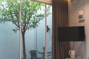 a room with a sliding glass door with a tree outside at PVILLA in Ban Phraek Sa